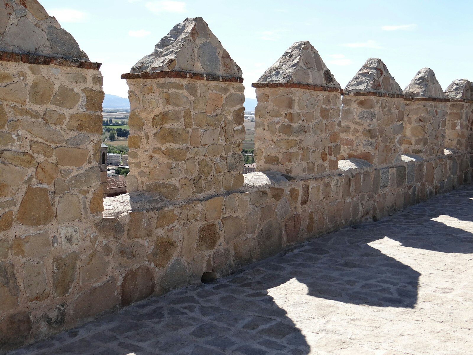 A stone wall with a row of stone pillars